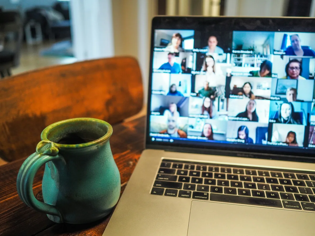 A team standup on a video call, open on a laptop